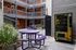 Charming apartment courtyard featuring vibrant purple picnic tables, modern string lights, and a convenient snack vending machine.