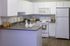 Modern kitchen with sleek white cabinetry, elegant countertops, and stylish appliances, offering a bright and welcoming space for culinary creativity.
