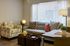 Chic modern living room with a stylish grey sofa, vibrant patterned cushions, and a designer armchair, complemented by an elegant coffee table and ambient lighting.