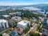 Vibrant aerial view of a picturesque urban neighborhood with colorful apartment buildings nestled near a scenic river and lush greenery.