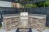 Chic outdoor grilling station featuring a sleek stainless steel BBQ and elegant stone counter set against a modern fenced patio backdrop.