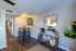 Inviting dining area with a modern high-top table, stylish decor, and vibrant green plants creating a warm, cozy apartment ambiance.