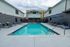 Inviting outdoor pool area with stylish loungers and sun umbrellas, perfect for relaxation and sunny days.