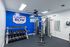 Modern gym at Campus Row Tallahassee featuring high-quality equipment, vibrant blue accent wall, and organized free weights for an energetic workout atmosphere.