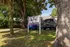 Inviting view of Campus Row in Tallahassee, showcasing a lush green landscape with ample parking and a welcoming entrance sign.
