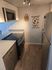 Contemporary kitchen featuring sleek stainless steel appliances and stylish wood flooring, illuminated by modern track lighting.