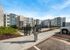 Modern apartment complex with sleek architecture, ample windows, and EV charging station, offering a convenient and eco-friendly lifestyle.