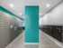 Modern mailroom with vibrant teal accent wall, featuring secure parcel lockers and spacious mailboxes.