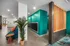Contemporary apartment lobby featuring colorful accent walls, sleek mailboxes, and modern furnishings with a touch of greenery.