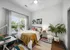 Bright and inviting bedroom with stylish decor, large window, and cozy workspace, perfect for modern living.