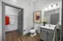 Modern bathroom with elegant artwork, sleek vanity, and stylish decor leading to a spacious walk-in closet.