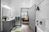 Modern bathroom with elegant vanity, stylish lighting, and a cozy view into a sunlit bedroom.