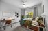 Bright and inviting bedroom with modern decor, featuring a cozy bed, functional desk, and large window with a scenic view.