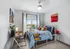 Bright and cheerful bedroom with modern decor, featuring a cozy bed with colorful pillows, a stylish desk, and abundant natural light from large windows.
