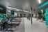 Modern fitness center with high-end treadmills, weightlifting equipment, and sleek gray flooring in a vibrant atmosphere.