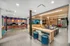 Modern co-living space featuring a vibrant workspace with computers and colorful decor, open seating area, and contemporary furnishings.