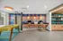 Vibrant community lounge with colorful wall art, modern workstations, and a yellow foosball table for relaxation and productivity.