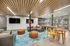 Modern communal space featuring cozy seating, vibrant decor, and large flat-screen TVs, perfect for relaxation and socializing.