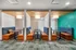 Modern seating area with stylish booths and vibrant decor, featuring cozy blue and orange cushions against a teal accent wall.
