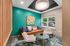 Chic lounge area with modern seating, vibrant artwork, and a view of serene greenery through the window.