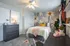 Charming bedroom with floral accent wall, cozy bed, and stylish decor, creating a warm and inviting atmosphere.