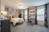 Chic bedroom with floral accent wall, elegant desk space, and abundant natural light, creating a cozy and inviting atmosphere.