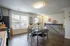 Bright and modern dining area with large window, stylish decor, and contemporary kitchen appliances, perfect for cozy gatherings.