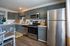 Contemporary kitchen with sleek gray cabinets, stainless steel appliances, and inviting dining area.