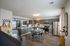Chic open-concept kitchen and dining area with modern cabinetry, stainless steel appliances, and warm wood flooring, seamlessly flowing into a cozy living room.