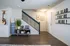 Welcoming entryway with modern decor, featuring a stylish staircase, a cozy reading nook, and vibrant artwork for a warm ambiance.