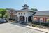 Charming apartment complex exterior with modern design, ample parking, and lush greenery.