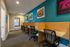 Bright and modern coworking space with vibrant art, featuring cozy workstations and ergonomic chairs.