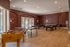 Inviting recreation room featuring a foosball table, ping pong, and pool tables with warm lighting and elegant decor.