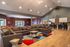 Inviting communal space with modern sofas, vibrant decor, and a stylish kitchen bar area perfect for social gatherings.