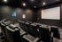 Chic apartment cinema room featuring plush seating, a large screen, and artistic decor, perfect for an immersive movie experience.