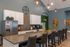 Modern communal kitchen with chic lighting, sleek countertops, and stylish bar seating, enhancing a vibrant social space.