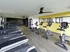 Modern gym with sleek treadmills and bikes, vibrant yellow accents, and motivational wall art, perfect for an energizing workout.