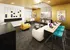 Vibrant recreation room featuring a foosball table, cozy seating, modern decor, and a tech-friendly workspace with sleek laptops.