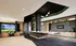 Modern lounge area with golf simulator, sleek bar seating, and contemporary decor, creating a vibrant social space.