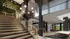Elegant modern lobby with sleek staircase, statement lighting, and lush greenery, welcoming residents home.
