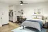 Modern bedroom with sleek design featuring a cozy bed, stylish desk, and organized open closet in a bright, inviting space.