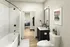 Modern bathroom with sleek fixtures, elegant artwork, and view into a cozy bedroom with stylish decor.