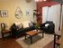 Chic living room with contemporary black sofas, stylish decor, and warm wood accents against a vibrant red accent wall.