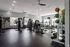 Spacious, well-equipped fitness center featuring modern gym equipment, cardio machines, and natural lighting.