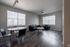 Contemporary apartment living room with sleek black furniture, large windows providing abundant natural light, and elegant wood flooring for a modern feel.