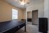 Bright and cozy bedroom with a large mirrored closet, comfortable bed, and a neat workspace, perfect for relaxation and productivity.