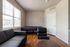 Bright and inviting living area with modern furnishings, large windows, and elegant wooden flooring.