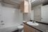 Modern bathroom design with elegant white tiles, sleek countertop, and ample storage space.