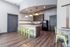 Modern communal kitchen with sleek countertops, vibrant green stools, and stylish lighting, perfect for casual gatherings.