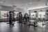 Modern gym featuring a variety of fitness equipment, including weight machines and cardio bikes, with ample natural light and sleek design.